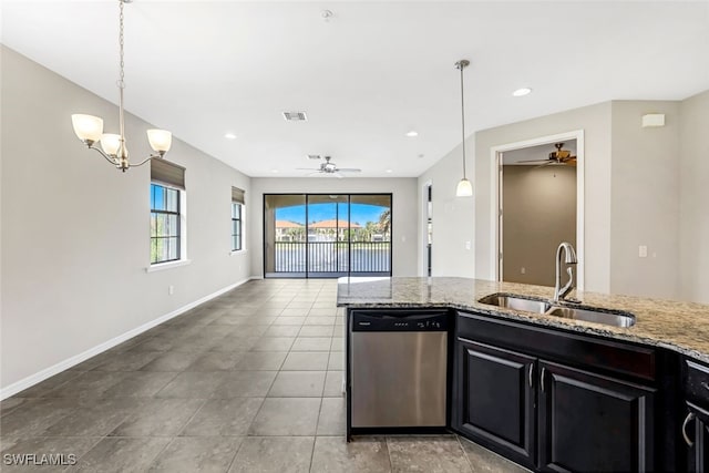 kitchen with hanging light fixtures, light stone countertops, sink, and dishwasher