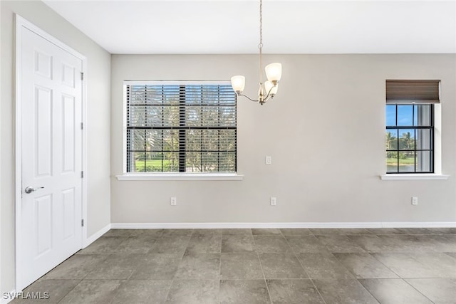 spare room featuring plenty of natural light and a notable chandelier