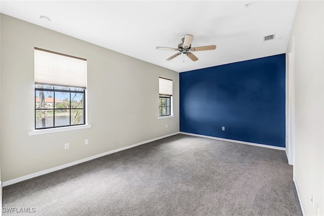 empty room with ceiling fan and carpet floors