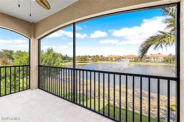 balcony featuring ceiling fan and a water view