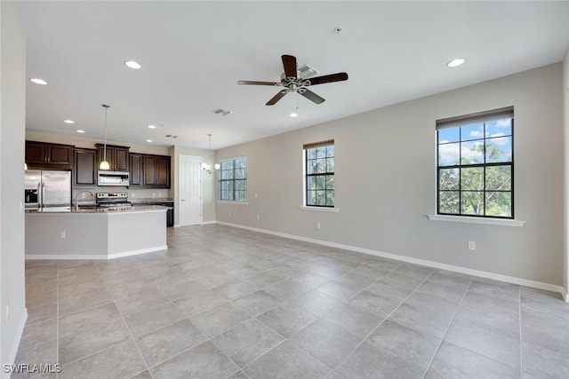 unfurnished living room with ceiling fan, recessed lighting, a sink, visible vents, and baseboards