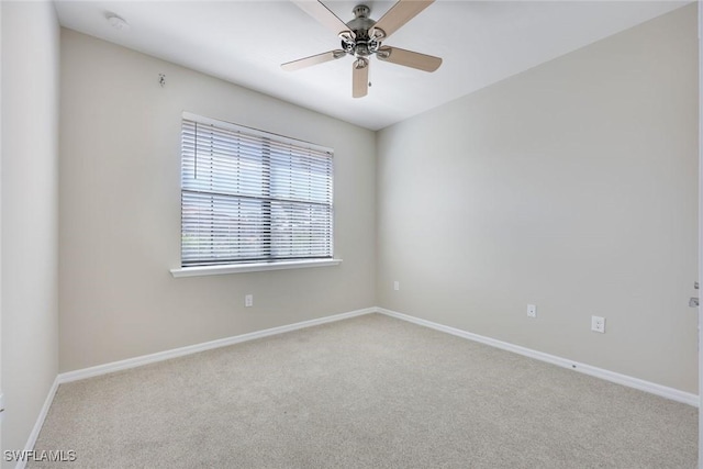 carpeted empty room with ceiling fan and baseboards