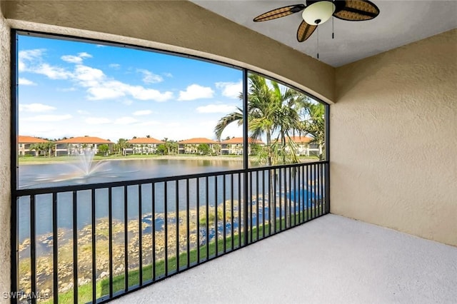 balcony featuring a residential view, a water view, and ceiling fan