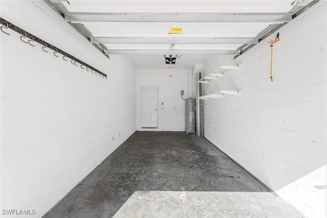 garage with concrete block wall, electric water heater, and a garage door opener