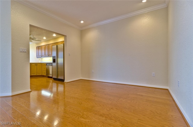 unfurnished room featuring crown molding, ceiling fan, and light hardwood / wood-style flooring