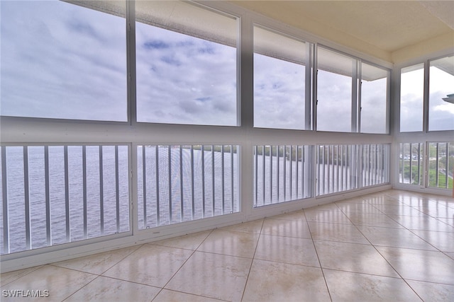 unfurnished sunroom with a water view and a healthy amount of sunlight