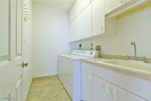 laundry area with light tile patterned flooring, cabinets, sink, and washing machine and clothes dryer