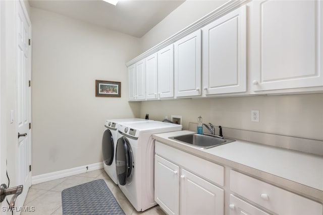 laundry area with cabinets, sink, washer and dryer, and light tile patterned flooring