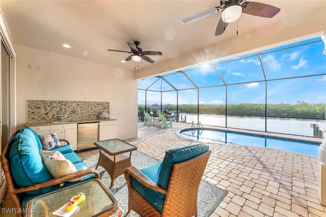 view of swimming pool featuring a lanai, a water view, ceiling fan, and a patio