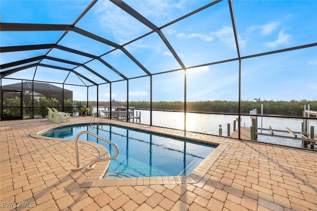 view of swimming pool featuring glass enclosure, a water view, a patio, and a boat dock