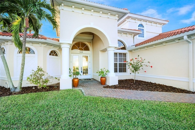 property entrance with a lawn and french doors