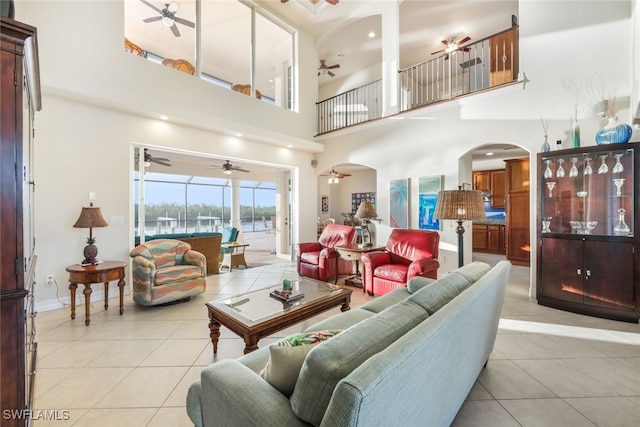 living room with a towering ceiling and light tile patterned floors