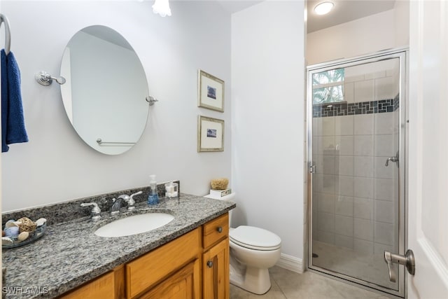 bathroom with tile patterned flooring, vanity, toilet, and a shower with door