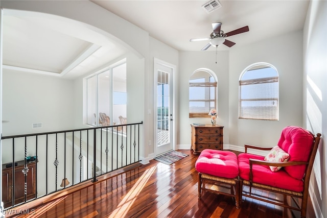 living area with dark hardwood / wood-style flooring and ceiling fan