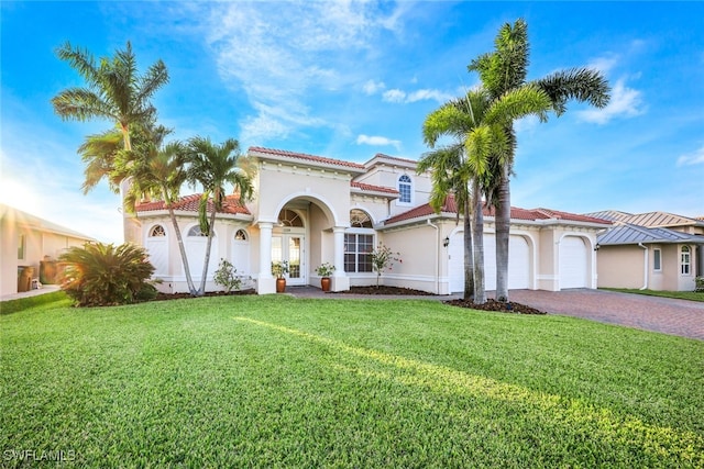 mediterranean / spanish-style house featuring a front lawn and a garage