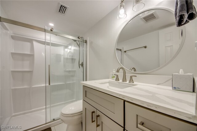 bathroom with tile patterned flooring, vanity, an enclosed shower, and toilet