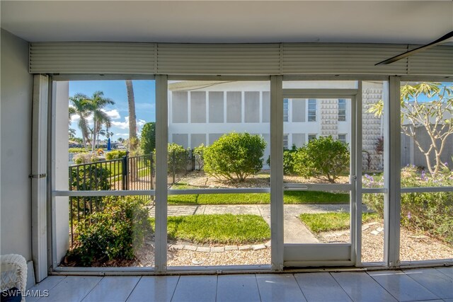 doorway to outside featuring a wealth of natural light and tile patterned flooring