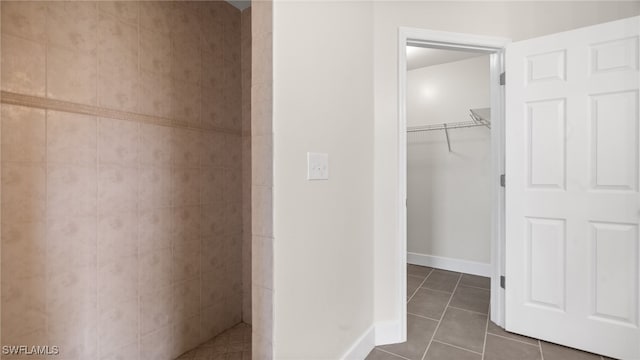 bathroom featuring walk in shower and tile patterned flooring