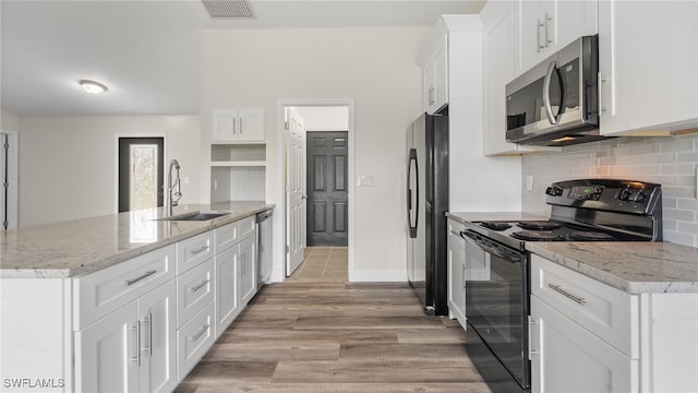 kitchen with stainless steel appliances, light hardwood / wood-style floors, sink, light stone countertops, and white cabinets