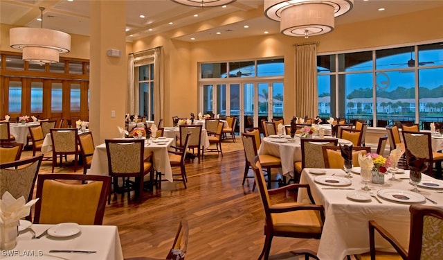 dining area with hardwood / wood-style flooring and a towering ceiling