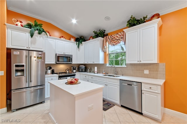 kitchen with stainless steel appliances, sink, lofted ceiling, a center island, and white cabinets