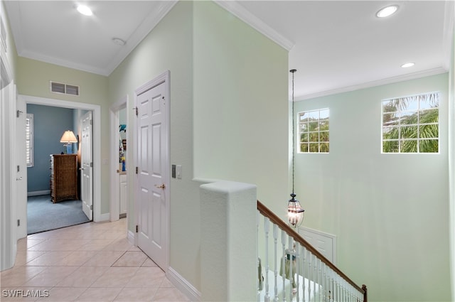 hall featuring light tile patterned floors and crown molding