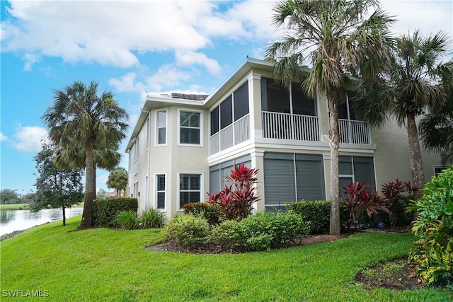 view of property exterior featuring a sunroom and a lawn