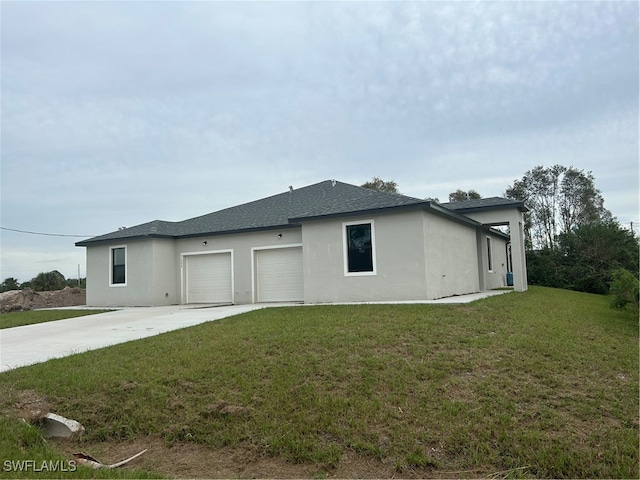 view of side of property featuring a garage and a lawn