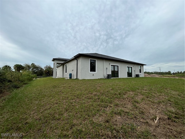 view of home's exterior with central AC and a yard