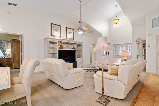 living room with high vaulted ceiling, ceiling fan, and light hardwood / wood-style flooring