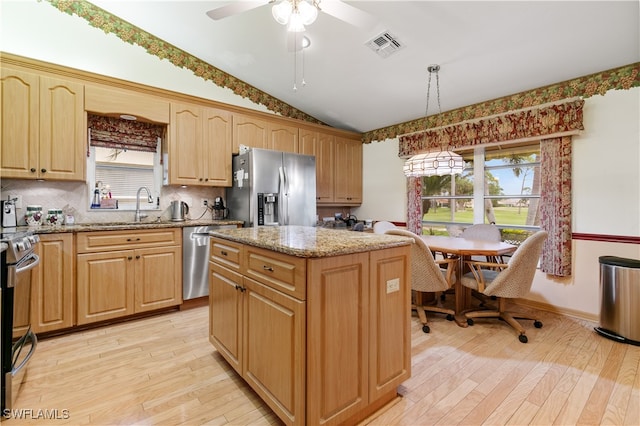 kitchen featuring pendant lighting, light wood-type flooring, stainless steel appliances, and a center island