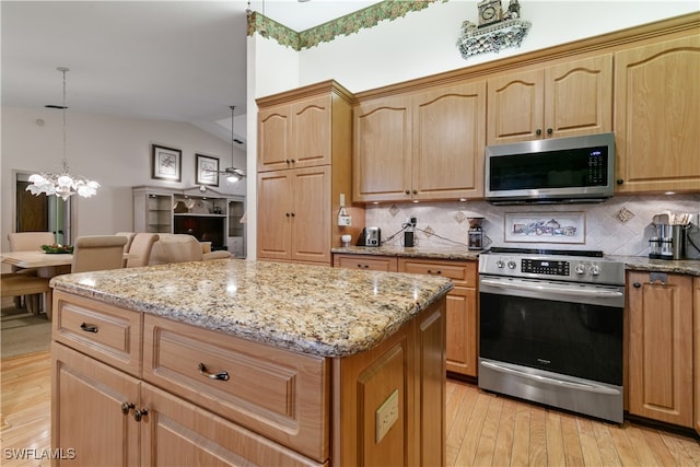 kitchen with stainless steel appliances, light hardwood / wood-style floors, hanging light fixtures, lofted ceiling, and decorative backsplash