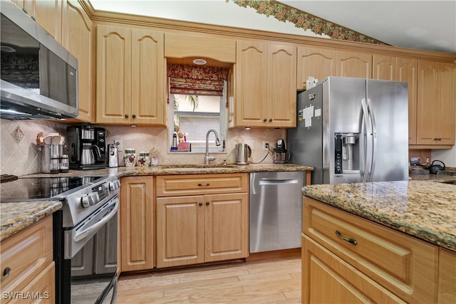 kitchen with light hardwood / wood-style flooring, sink, light stone counters, and stainless steel appliances