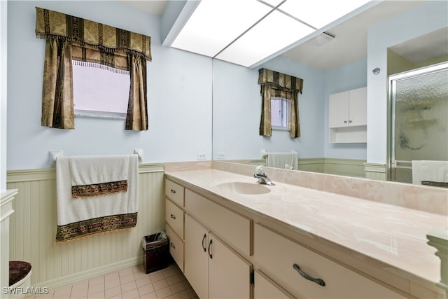 bathroom featuring tile patterned flooring, vanity, and a shower with shower door