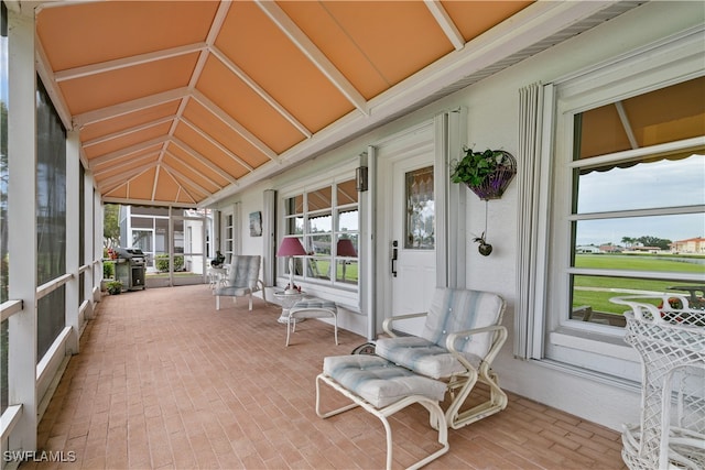 sunroom featuring a wealth of natural light and vaulted ceiling