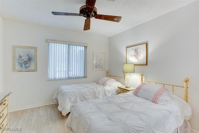 bedroom featuring ceiling fan, a textured ceiling, and light wood-type flooring