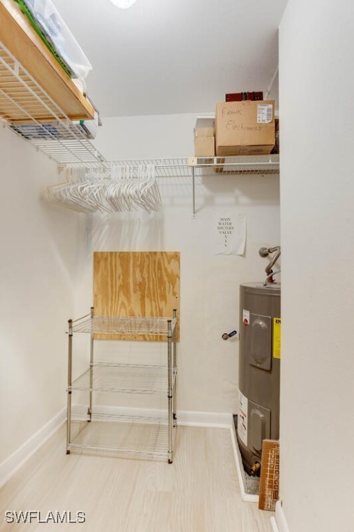 walk in closet featuring electric water heater and wood-type flooring