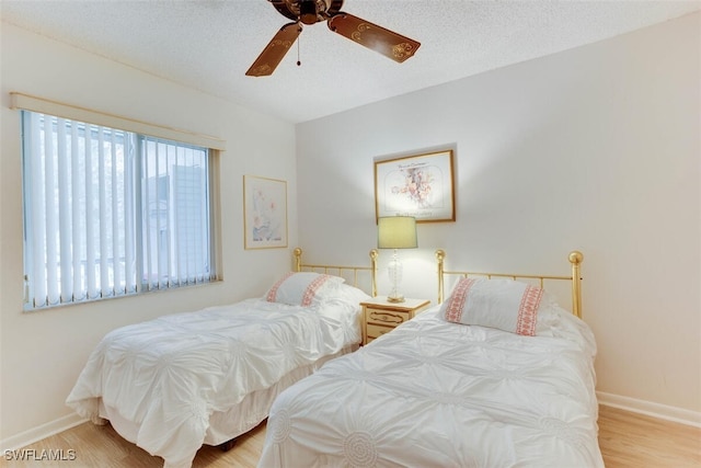 4351 27th Ct SW Unit 203, Naples, FL 34116 - bedroom with wood finished floors, baseboards, ceiling fan, and a textured ceiling