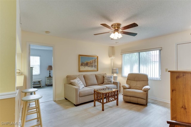 4351 27th Ct SW Unit 203, Naples, FL 34116 - living area with plenty of natural light, a ceiling fan, light wood finished floors, baseboards, and a textured ceiling