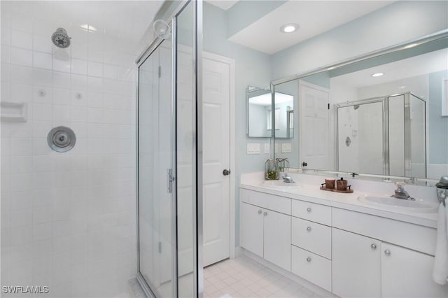 bathroom with a stall shower, a sink, recessed lighting, and double vanity