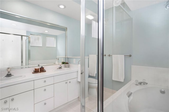 bathroom with double vanity, a stall shower, toilet, a sink, and a bath