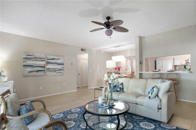 living room with light hardwood / wood-style flooring and ceiling fan