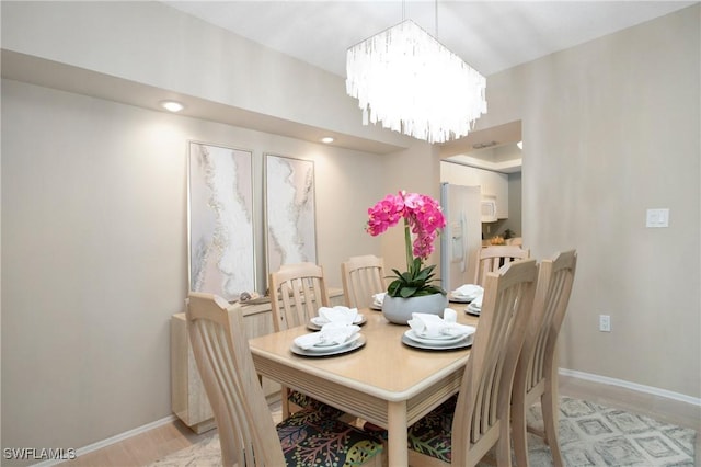 dining room with baseboards and an inviting chandelier