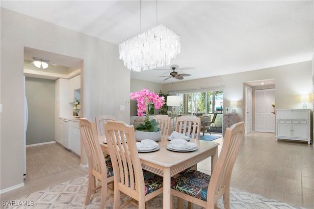 dining space featuring ceiling fan with notable chandelier