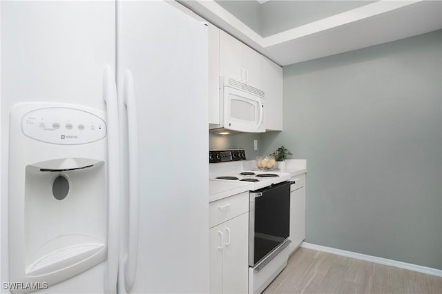 kitchen with white appliances, light hardwood / wood-style flooring, and white cabinetry