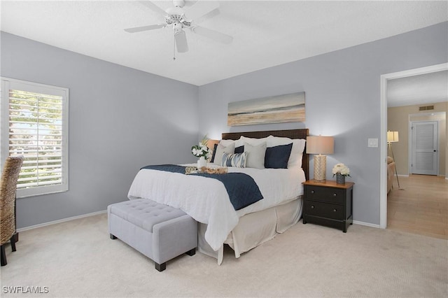 bedroom featuring light carpet, ceiling fan, visible vents, and baseboards