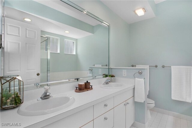 bathroom with tile patterned floors, vanity, toilet, and an enclosed shower