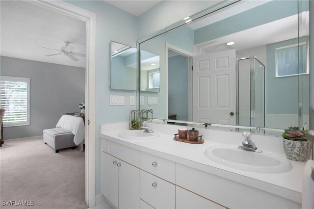 bathroom featuring ceiling fan, vanity, and an enclosed shower