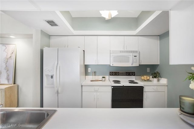 kitchen featuring light countertops, white appliances, and white cabinets