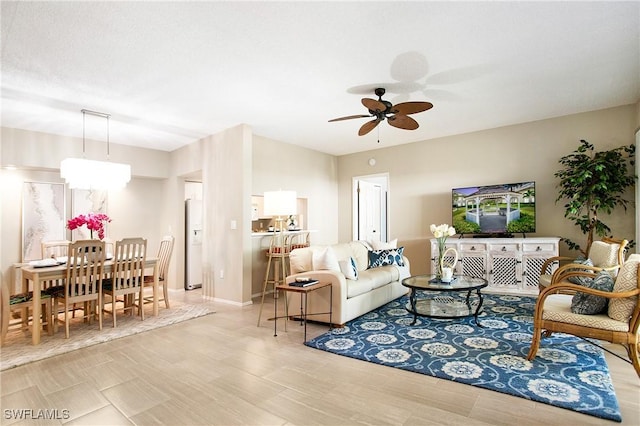 living area featuring ceiling fan and baseboards